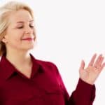 Smiling, relaxed woman with hair softly fluttering in breeze representing someone who has overcome anger.